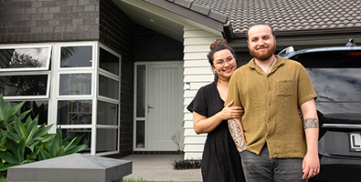 Couple standing in front of house
