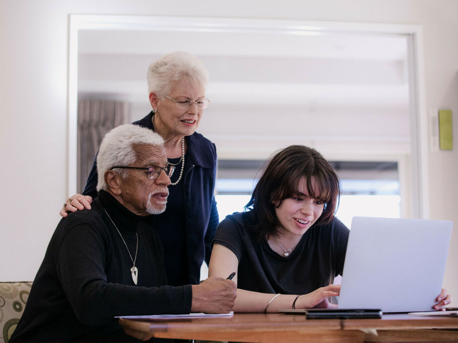 three people looking at a laptop