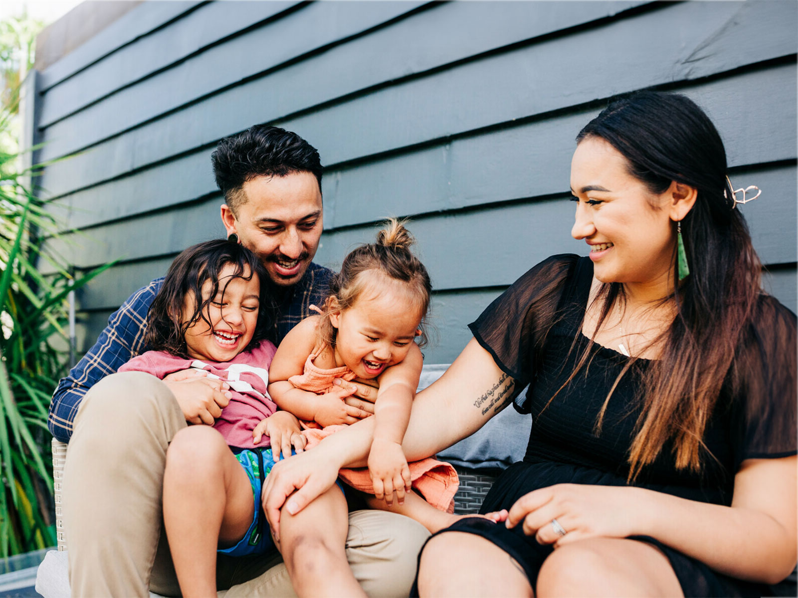 A happy family of four relaxing outside 